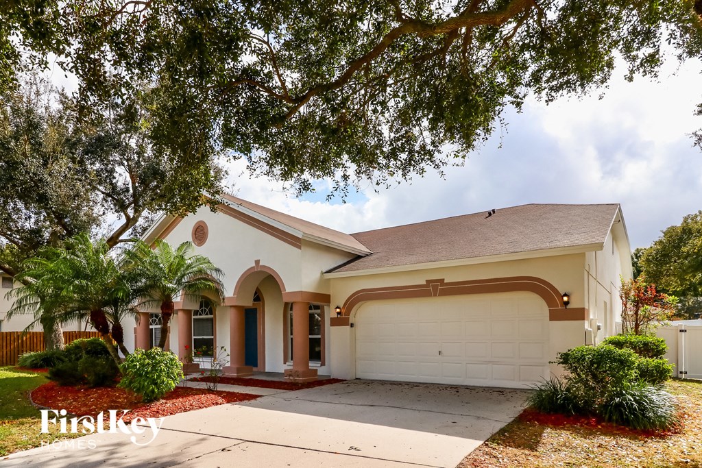 a house with a white garage door and a palm tree