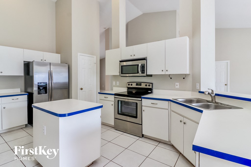 a kitchen with white cabinets and stainless steel appliances