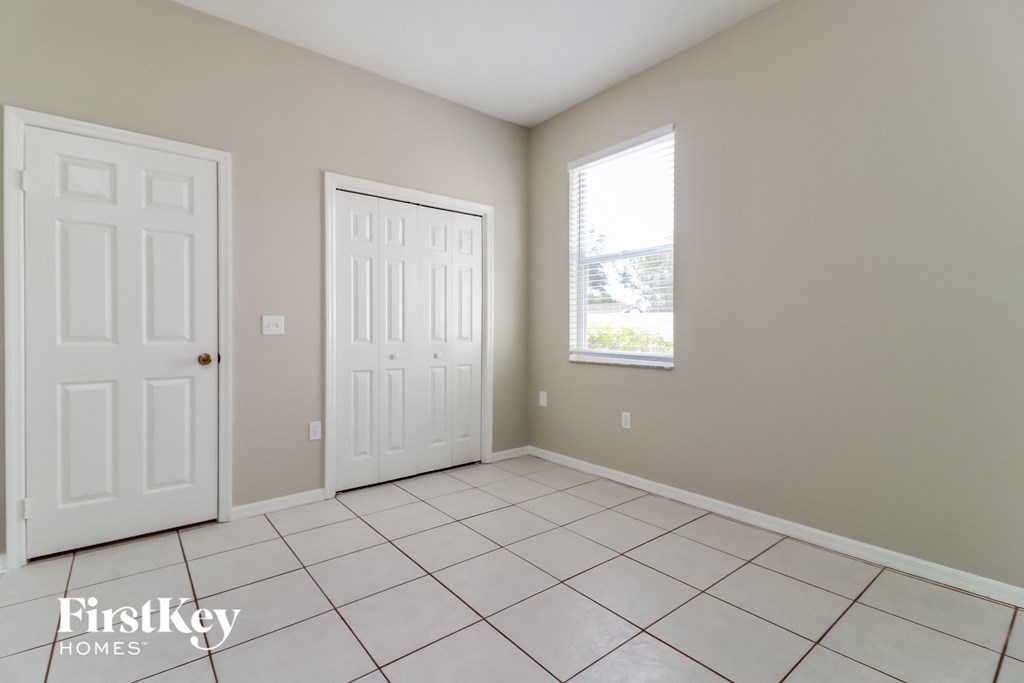 an empty living room with two doors and a tiled floor