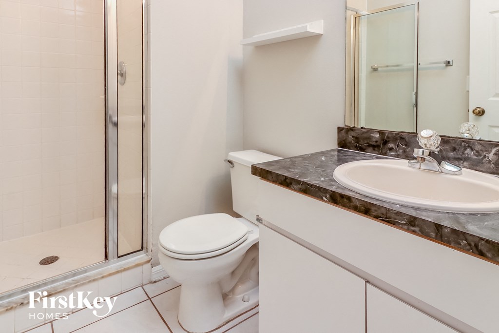 a bathroom with a toilet and a sink and a shower