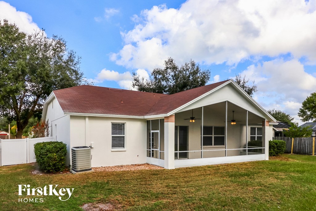 a small white house with a lawn and a white fence