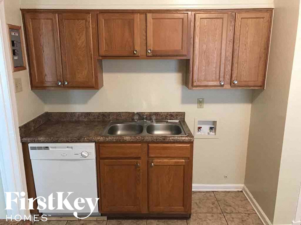 A kitchen with wooden cabinets and a washing machine.