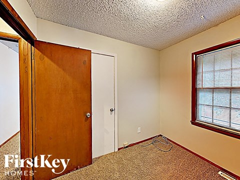 the master bedroom has a door to the closet and a window