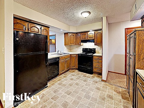 a kitchen with black appliances and wooden cabinets