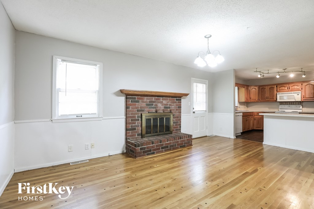 A room with a fireplace and wooden floors.