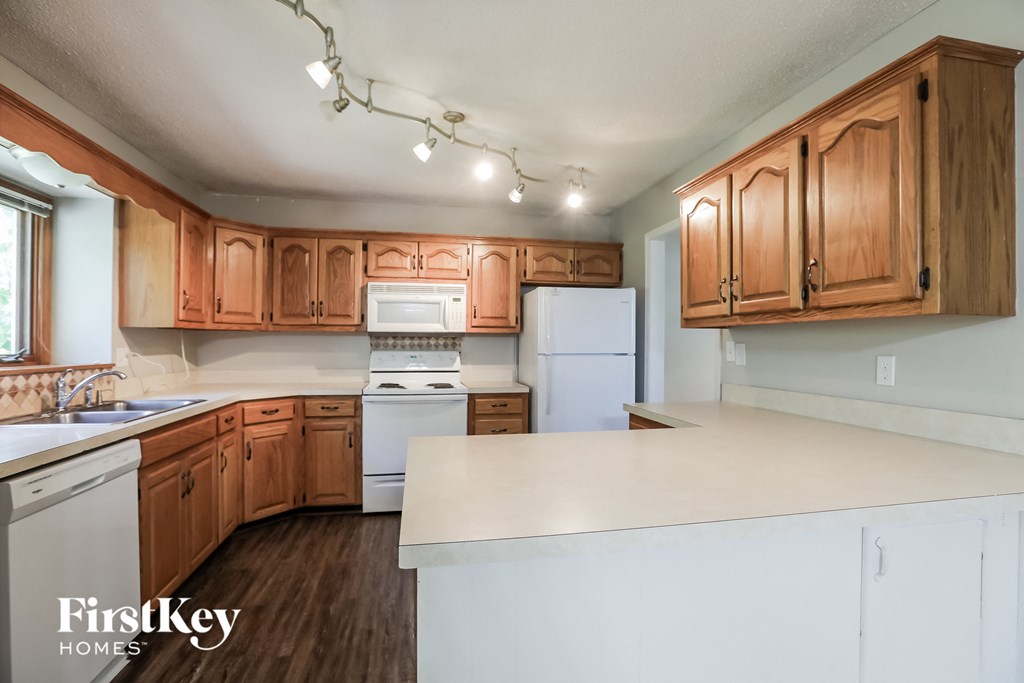 A kitchen with wooden cabinets and white appliances.