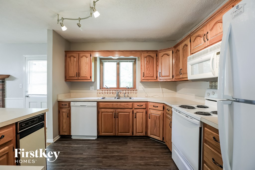 A kitchen with wooden cabinets and a white fridge.