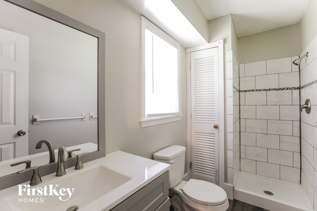 A bathroom with a white sink and toilet.