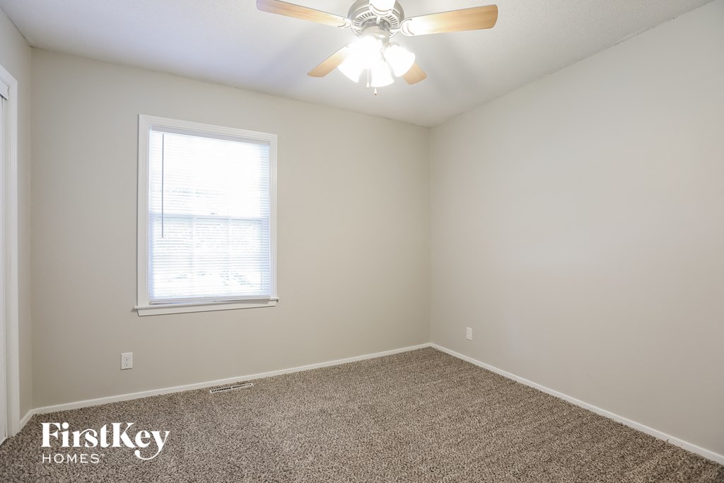A room with a ceiling fan and a window.
