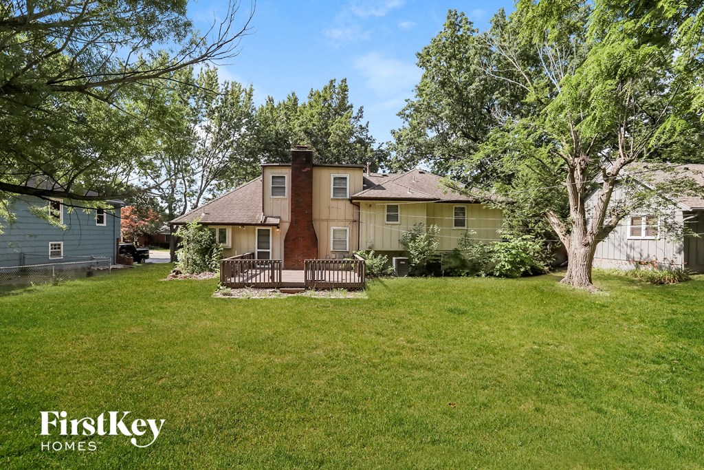 A house with a lawn and trees in front of it.