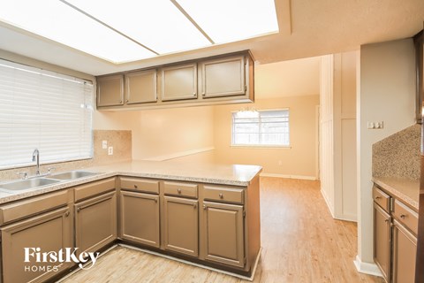 A kitchen with wooden cabinets and a skylight.