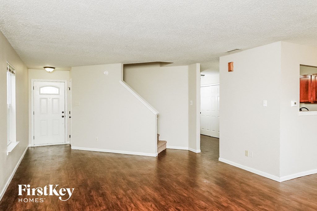 a living room with a hard wood floor and white walls
