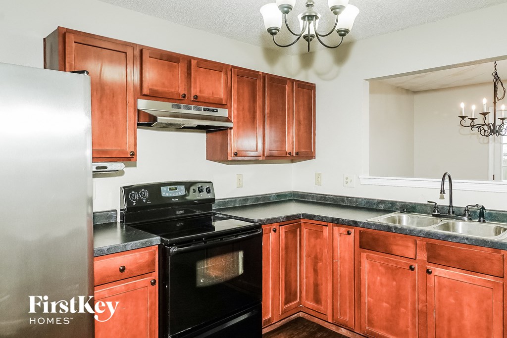 a kitchen with wood cabinets and black appliances and a refrigerator
