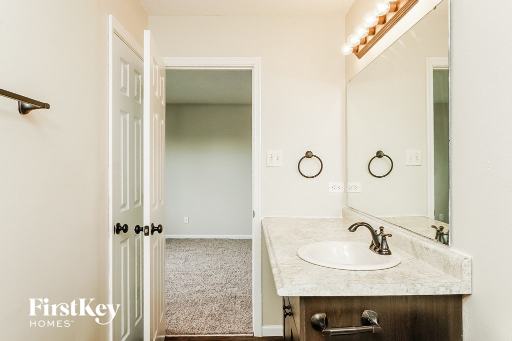 a bathroom with a sink and a mirror and a closet