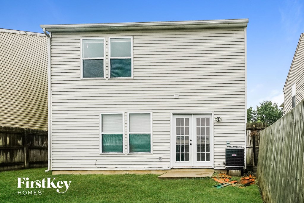 the outside of a white house with white siding and green grass