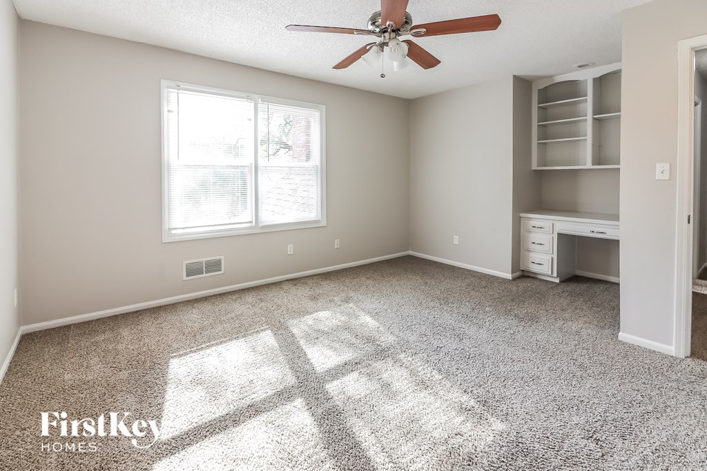 an empty room with a ceiling fan and a window