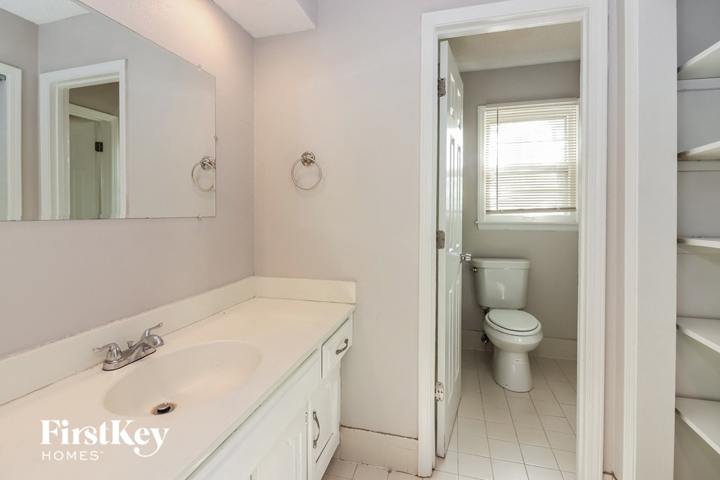 a bathroom with a toilet and a sink and a mirror