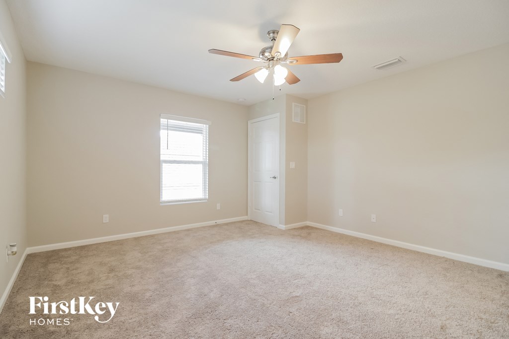 a bedroom with carpet and a ceiling fan