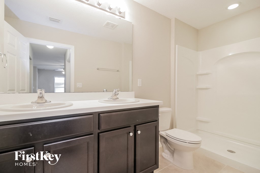 a bathroom with two sinks and a toilet and a mirror