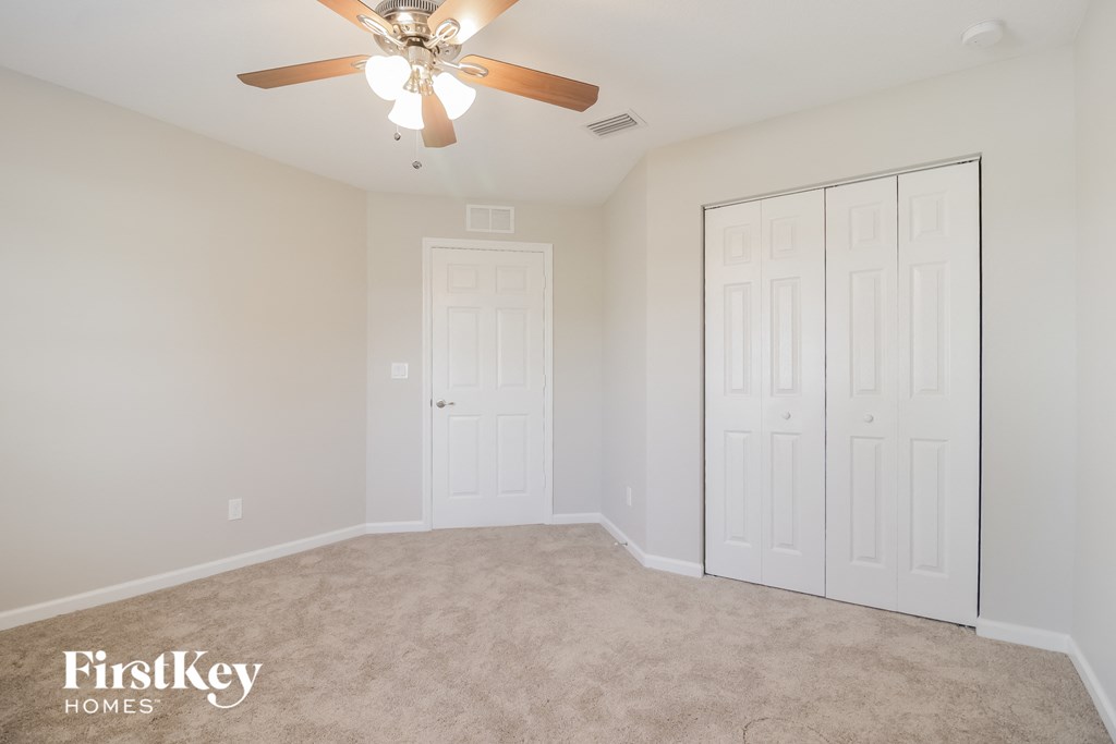 a bedroom with two closets and a ceiling fan