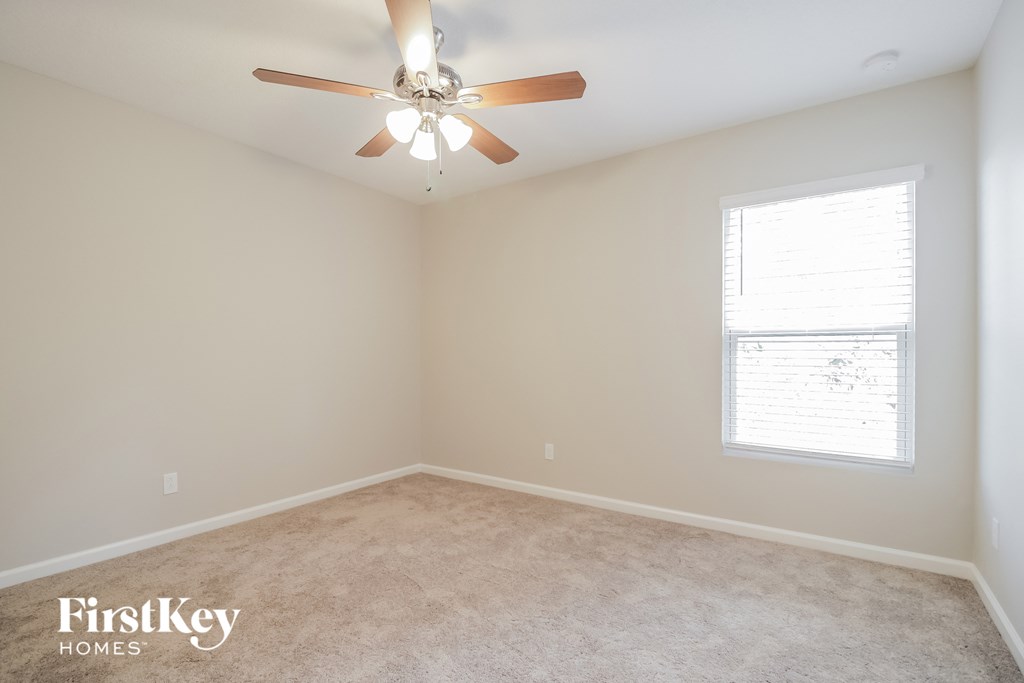 a bedroom with a ceiling fan and a window