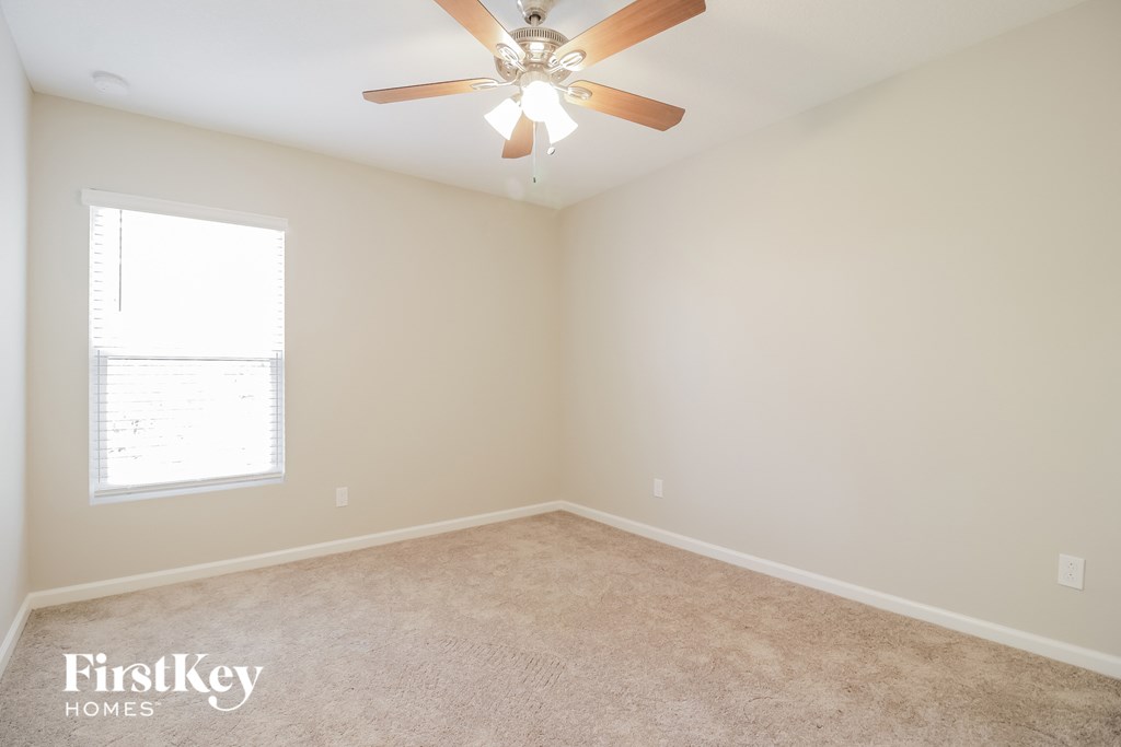 a bedroom with a ceiling fan and a window