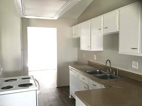 A kitchen with white cabinets and a stove top oven.