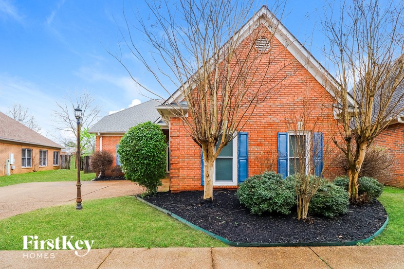 a brick house with a front yard and a sidewalk
