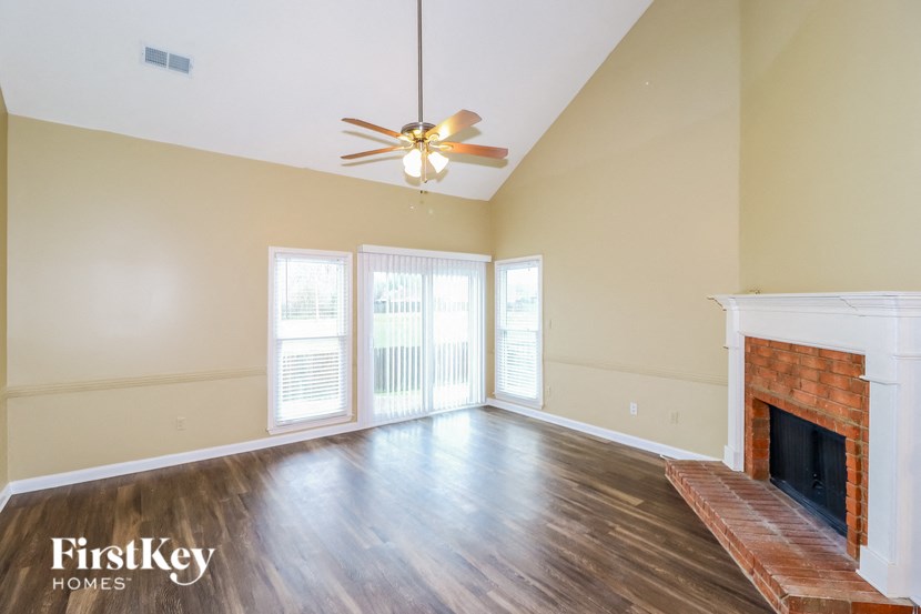 a living room with a fireplace and a ceiling fan