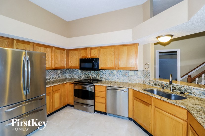 the kitchen has stainless steel appliances and granite counter tops