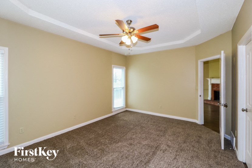an empty living room with carpet and a ceiling fan