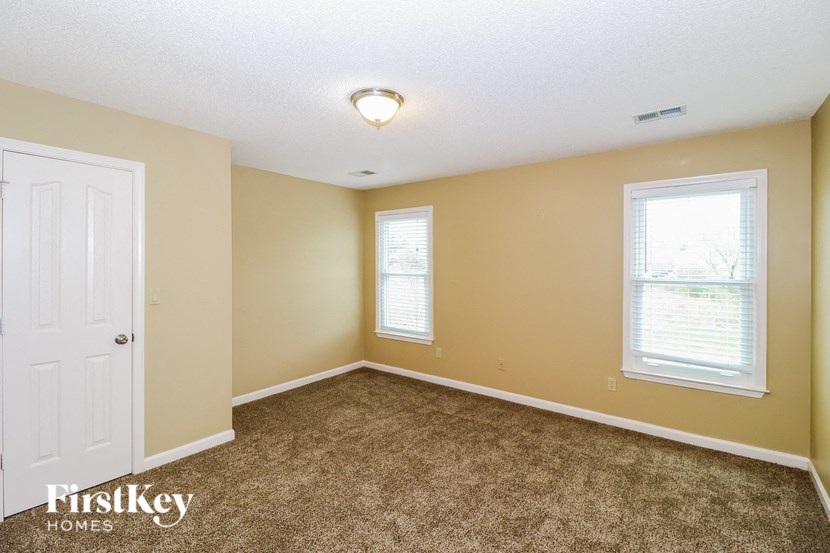 a bedroom with a carpeted floor and a white door