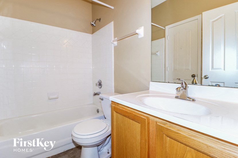 a bathroom with a sink toilet and tub and a mirror