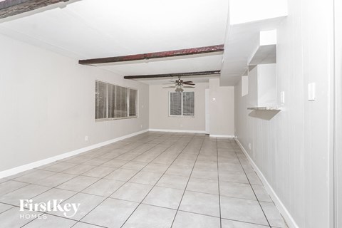 A spacious room with white walls and a tiled floor.