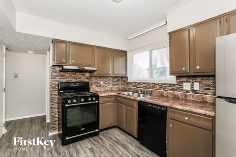 A kitchen with brown cabinets and a black stove top oven.