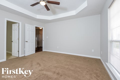 a living room with a carpet and a ceiling fan