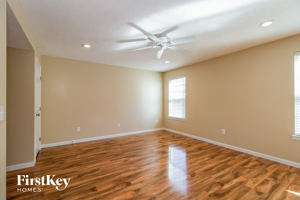 a living room with wooden floors and a ceiling fan
