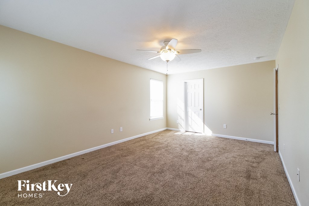 a living room with carpet and a ceiling fan