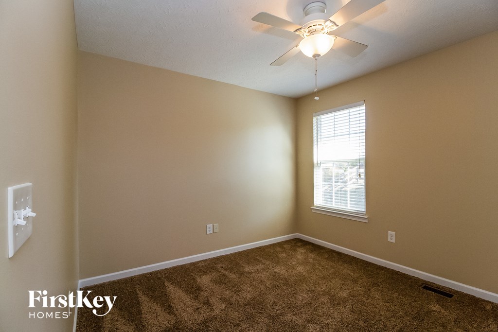a bedroom with carpet and a ceiling fan