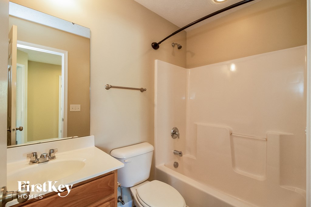 a bathroom with a toilet and a tub and a sink