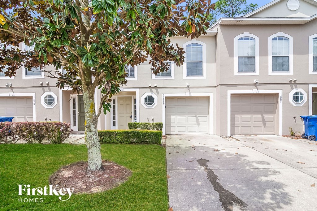 a house with two garage doors and a tree in front of it