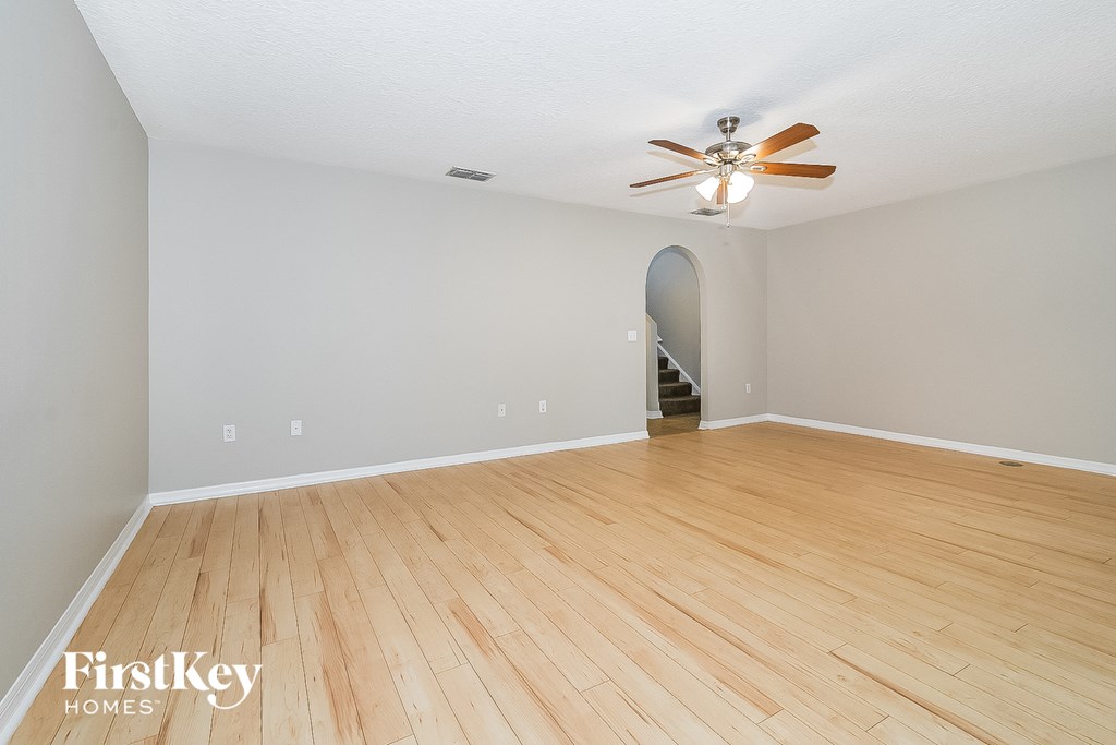 the living room with hardwood floors and a ceiling fan