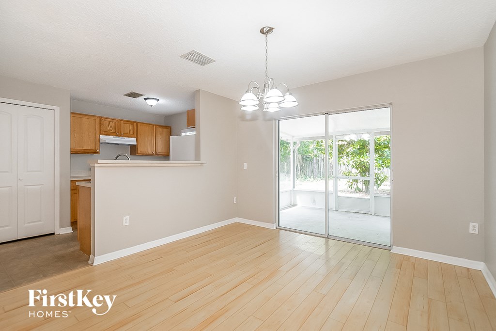 a living room and kitchen with wood floors and a sliding glass door