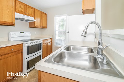 a kitchen with wooden cabinets and a stainless steel sink