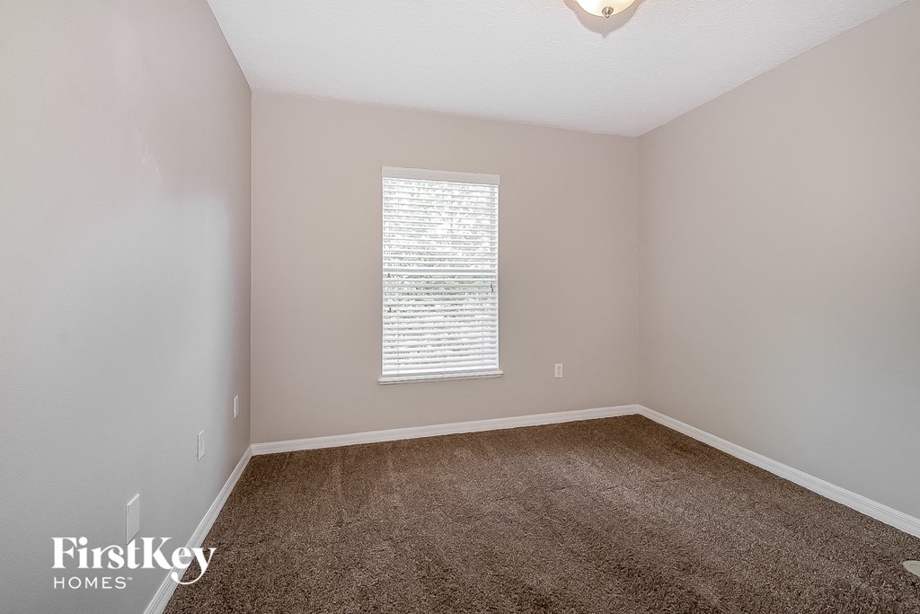 an empty room with carpet and a window