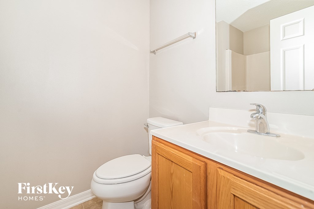 a bathroom with a sink toilet and a mirror