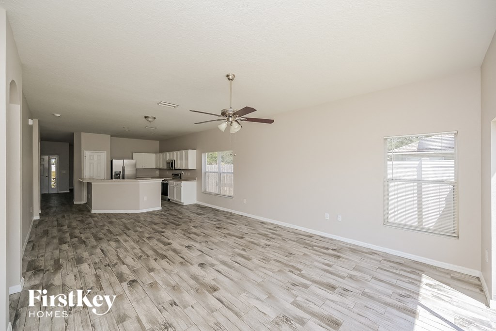 A spacious room with a fan and wooden flooring.