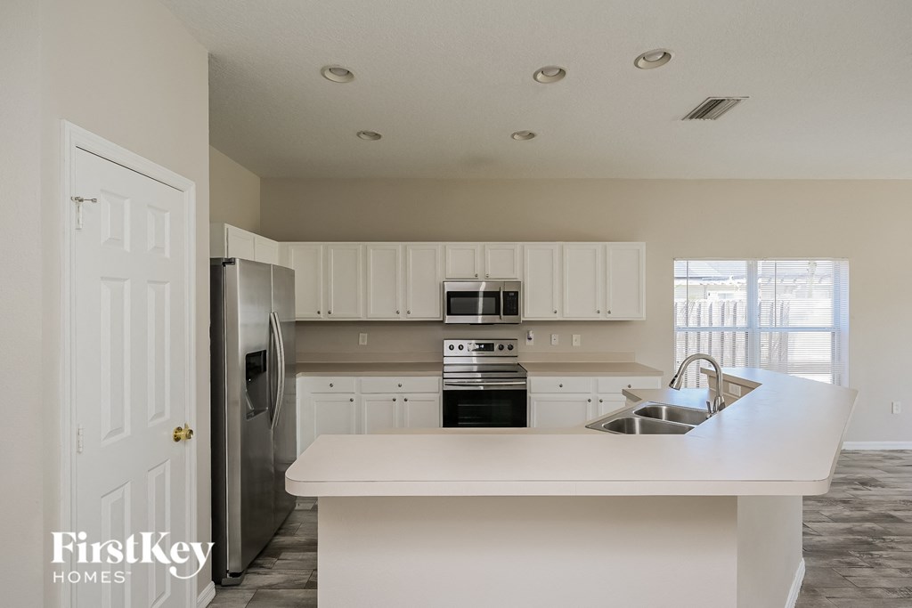 A kitchen with a white island and stainless steel appliances.