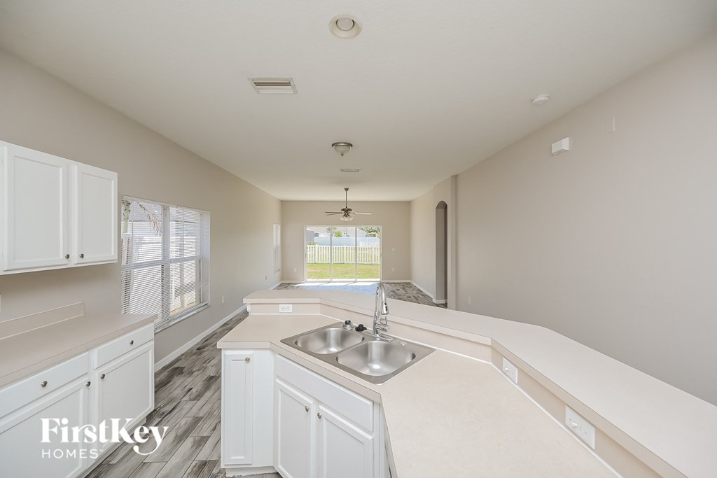 A kitchen with white cabinets and a sink is shown.