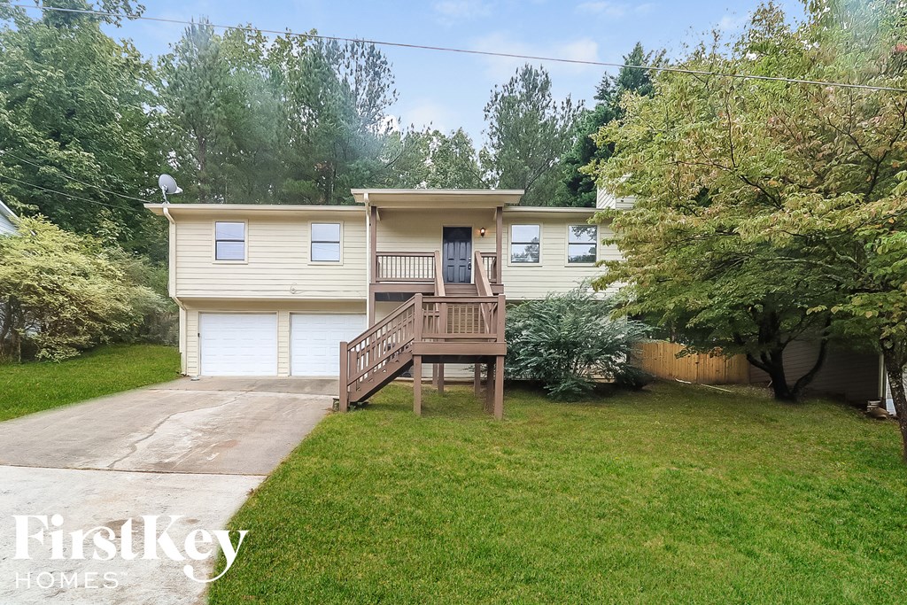 the front of a house with a yard and a deck